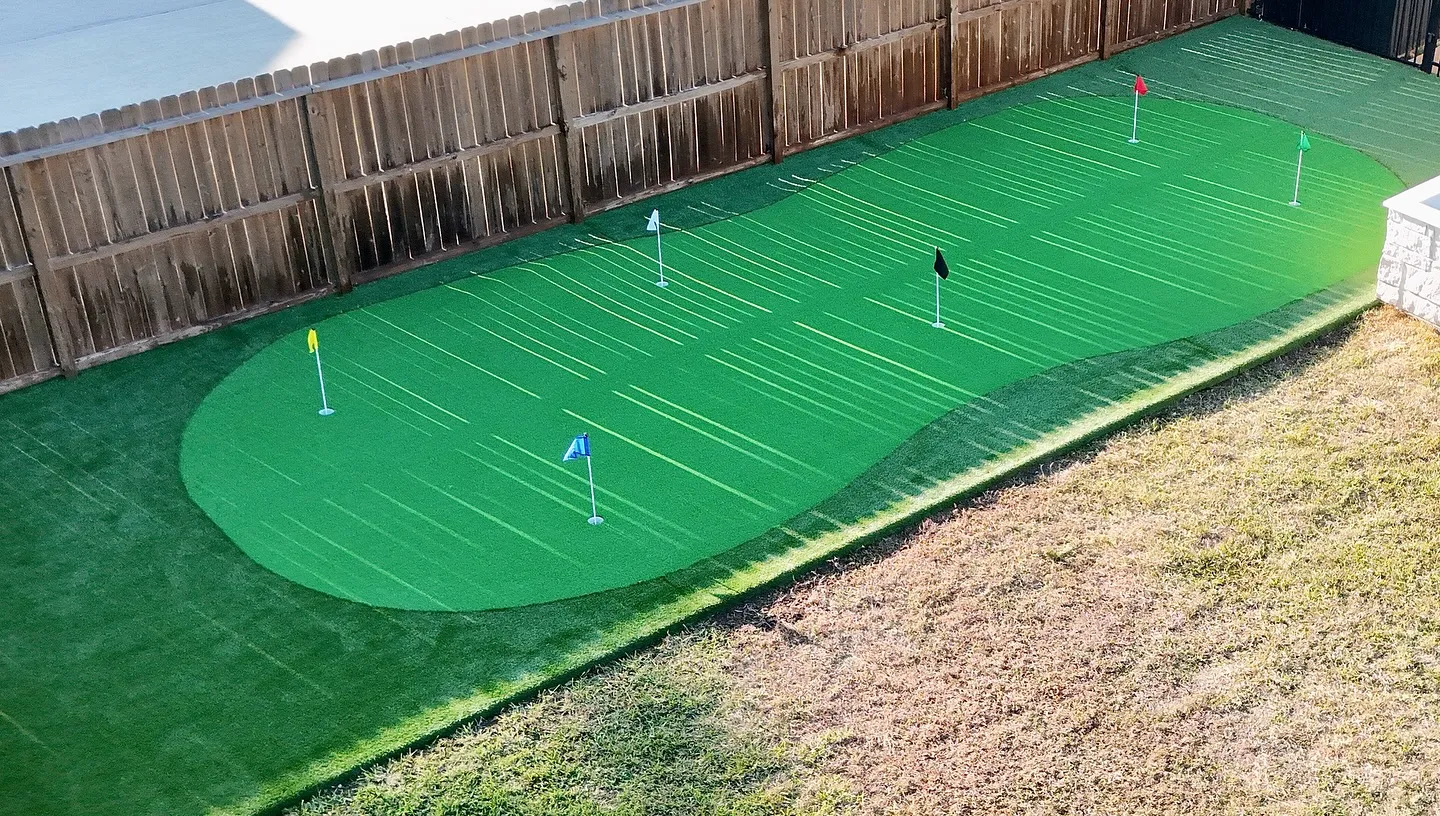 Completed synthetic turf yard with mature landscape integration